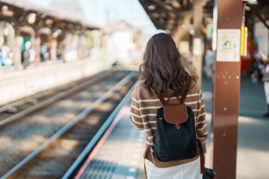 Kamakura, Kanagawa, Japonya 'da tren bekleyen ve ziyaret eden kadın turist. Gezginler Kamakura tren istasyonunu gezerken mutlu olsun. Tokyo yakınlarındaki turistler için önemli ve popüler bir yer. Seyahat ve Tatil