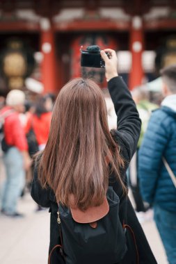 Sensoji Tapınağı 'nı ziyaret eden turist kadın veya Asakusa Kannon Tapınağı, Asakusa' da bulunan bir Budist tapınağıdır. Tokyo, Japonya ve Asya 'daki turistik ve turistik merkezler açısından önemli bir yere sahiptir.