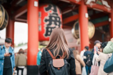 Sensoji Tapınağı 'nı ziyaret eden turist bir kadın veya Asakusa Kannon Tapınağı, Tokyo, Asakusa' da bulunan bir Budist tapınağıdır. Kırmızı fenerde Japonca cümle Şimşek kapısı anlamına gelir.