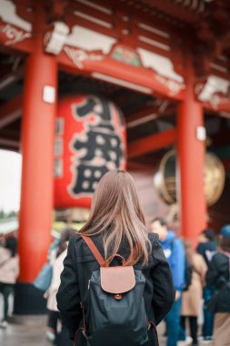 Sensoji Tapınağı 'nı ziyaret eden turist bir kadın veya Asakusa Kannon Tapınağı, Tokyo, Asakusa' da bulunan bir Budist tapınağıdır. Kırmızı fenerde Japonca cümle Şimşek kapısı anlamına gelir.