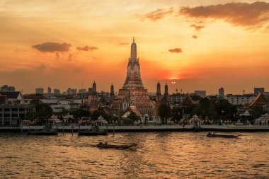 Gün batımında Wat Arun Tapınağı, Chao Phraya nehrinin yanında Şafak Tapınağı. Kent simgesi ve Bangkok, Tayland ve Güneydoğu Asya 'daki turizm ve turizm merkezleriyle ünlüdür.
