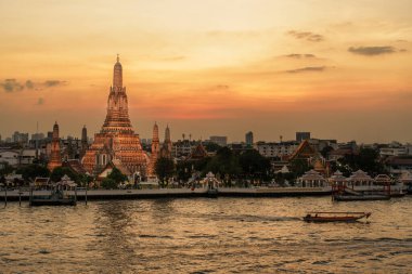 Gün batımında Wat Arun Tapınağı, Chao Phraya nehrinin yanında Şafak Tapınağı. Kent simgesi ve Bangkok, Tayland ve Güneydoğu Asya 'daki turizm ve turizm merkezleriyle ünlüdür.