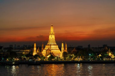 Gün batımında Wat Arun Tapınağı, Chao Phraya nehrinin yanında Şafak Tapınağı. Kent simgesi ve Bangkok, Tayland ve Güneydoğu Asya 'daki turizm ve turizm merkezleriyle ünlüdür.
