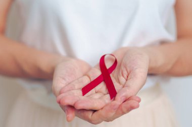 Mart ayı için Burgundy Red Ribbon kullanan kadın çoklu miyelom kanseri ve Aralık ayı AIDS farkındalığı. Sağlık ve dünya kanser günü konsepti