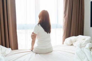 Evde yatakta yatarken kolu ağrıyan bir kadın, uyandıktan sonra kas hasarı ve ağrısı. Sağlık ve Tıp Konsepti