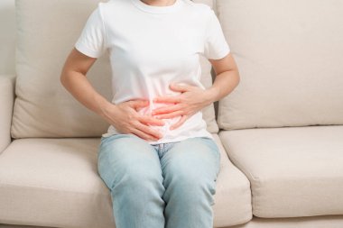 Karın ağrısı, kabızlıktan dolayı sindirim ya da gıda zehirlenmesinden kaynaklanan ishal, kadın sorunu ve endometriyozis, histerektomi ve regl geçiren bir kadın.