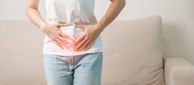Kadın problemi ve endometriyozis, histerektomi ve regl evdeki kanepede, karın ağrısı, kabızlık ve ishal nedeniyle karın ağrısı olan bir kadın.