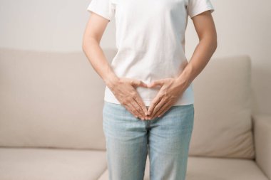 Karın bölgesinden kalp şeklinde bir kadın. Yumurtalık ve Servikal Kanser, Endometriyozis, Histektomi, Rahim fibroidi, Üreme, Adet, Mide, Hamilelik ve Cinsel Hastalıklar Konsepti