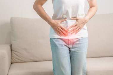 Kadın problemi ve endometriyozis, histerektomi ve regl evdeki kanepede, karın ağrısı, kabızlık ve ishal nedeniyle karın ağrısı olan bir kadın.