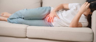 Kadın problemi ve endometriyozis, histerektomi ve regl evdeki kanepede, karın ağrısı, kabızlık ve ishal nedeniyle karın ağrısı olan bir kadın.