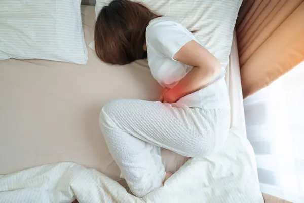 woman having abdomen ache due to Stomach pain, digestion with constipation or Diarrhea from food poisoning, female problem and Endometriosis, Hysterectomy and Menstrual on the bed at home