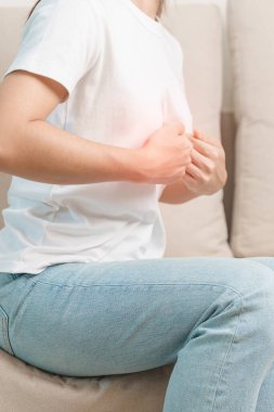 Karın ağrısı, kabız olmuş sindirim ya da evdeki kanepede yemek zehirlenmesi ve karaciğer kanseri nedeniyle karnı ağrıyan bir kadın.