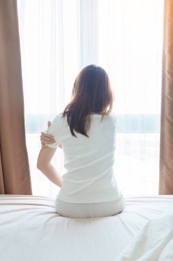 Evde yatakta yatarken kolu ağrıyan bir kadın, uyandıktan sonra kas hasarı ve ağrısı. Sağlık ve Tıp Konsepti