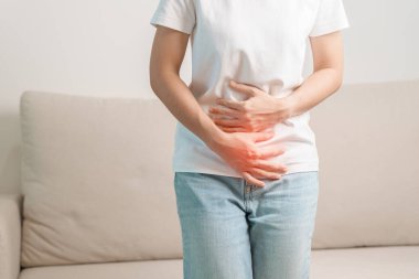 Karın ağrısı, kabızlıktan dolayı sindirim ya da gıda zehirlenmesinden kaynaklanan ishal, kadın sorunu ve endometriyozis, histerektomi ve regl geçiren bir kadın.