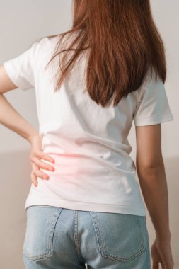 Evdeki koltukta otururken sırt ağrısı çeken bir kadın. Piriforis Sendromu, bel ağrısı ve omurga baskısı nedeniyle kas ağrısı olan yetişkin bir kadın. Ofis sendromu ve tıbbi konsept