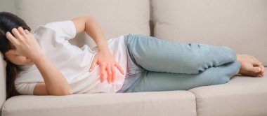 Kadın problemi ve endometriyozis, histerektomi ve regl evdeki kanepede, karın ağrısı, kabızlık ve ishal nedeniyle karın ağrısı olan bir kadın.