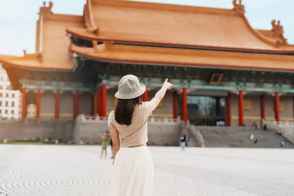 woman traveler visiting in Taiwan, Tourist with hat sightseeing in National Chiang Kai shek Memorial or Hall Freedom Square, Taipei City. landmark and popular attractions. Asia Travel concept