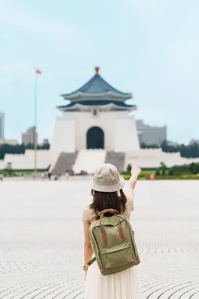 woman traveler visiting in Taiwan, Tourist with backpack sightseeing in National Chiang Kai shek Memorial or Hall Freedom Square, Taipei City. landmark and popular attractions. Asia Travel concept