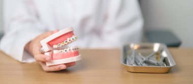 Ortodontik diş modelli, parantez ya da destekli bir diş hekimi. Tartarı temizleyin ve kazıyın. Mayıs Ortodonti Sağlık Günü, Mart Sağlığı, Diş Hekimleri Günü, Takma Diş. Diş Ağrısı ve Çocuk Diş Sağlığı