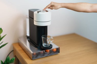 Kahve makinesinden Espresso Kahvesi ve ahşap masa çubuğunda kavrulmuş kahve çekirdeği. Ev, Apartman ve Ofis 'te günlük içecek konsepti