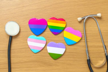LGBT gurur ayı kavramı veya LGBTQ + veya LGBTQIA +. Lezbiyen, Gay, Biseksüel, Transseksüel, Eşcinsel ve Panseksüel toplulukları için stetoskop ile gökkuşağı ve renkli kalp şekli