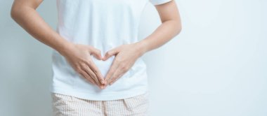Karın bölgesinden kalp şeklinde bir kadın. Yumurtalık ve Servikal Kanser, Endometriyozis, Histektomi, Rahim fibroidi, Üreme, Adet, Mide, Hamilelik ve Cinsel Hastalıklar Konsepti