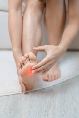 Eklem iltihabı ve kas ağrısı giderici krem konsepti. Evde yalınayak acı çeken bir kadın. Ayak ağrısı Plantar fasiiti ve uzun zamandır uyanık. Sağlık ve Sağlık