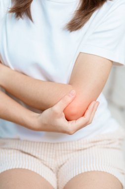Kadının evinde dirsek ağrısı, yan epikondilit ya da tenis dirseği yüzünden kas ağrısı var. yaralanma, sağlık ve tıbbi konsept