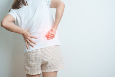 Evde sırt ağrısı çeken bir kadın. Piriforis Sendromu, bel ağrısı ve omurga baskısı nedeniyle kas ağrısı olan yetişkin bir kadın. Ofis sendromu ve tıbbi konsept