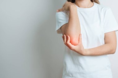 Kadının evinde dirsek ağrısı, yan epikondilit ya da tenis dirseği yüzünden kas ağrısı var. yaralanma, sağlık ve tıbbi konsept