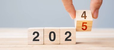 2024 'ten 2025' e kadar olan el çevirme bloğu masada. Çözüm, gözden geçirme, strateji, yıl sonu, hedef, iş ve yeni yıl tatil kavramları