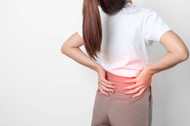 Gri arka planda kas ağrısı olan yetişkin bir kadın. Piriforis Sendromu, bel ağrısı ve omurga baskısı nedeniyle sırt ağrısı çeken yaşlı bir kadın. Ofis sendromu ve tıbbi konsept