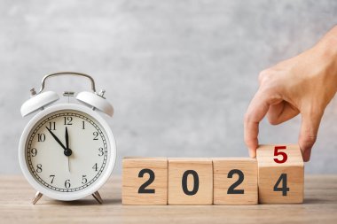 Klasik çalar saat ve 2024 'ü çevirip 2025 Blok' a çevirerek mutlu yıllar. Noel, Yeni Başlangıç, Çözüm, Geri sayım, Hedefler, Planlar, Eylem ve Motivasyon Konsepti