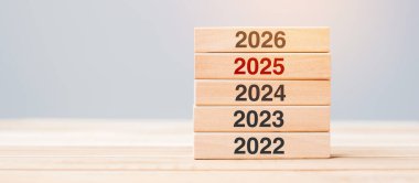 2025 üzerinde 2026 blok ve masa arkasında 2024 ahşap bina. İş planlaması, Risk Yönetimi, Çözüm, Strateji, Çözüm, Hedef, Yeni Yıl Yeni Sen ve Mutlu Noeller kavramları