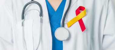 Dünya Hepatit Günü farkındalık ayı, 28 Temmuz. Doktor kırmızı ve sarı kurdele tutuyor. Karaciğer kanseri, sarılık, siroz, başarısızlık, büyüme, Hepatik Ensefalopati ve Sağlık Konsepti