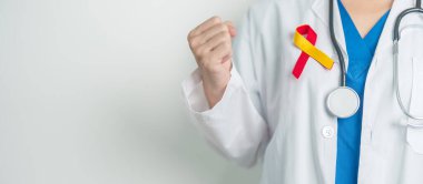 Dünya Hepatit Günü farkındalık ayı, 28 Temmuz. Doktor kırmızı ve sarı kurdele tutuyor. Karaciğer kanseri, sarılık, siroz, başarısızlık, büyüme, Hepatik Ensefalopati ve Sağlık Konsepti