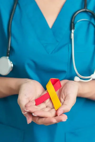 stock image World hepatitis day awareness month, 28 July. Doctor holding Red and Yellow ribbon. Liver cancer, Jaundice, Cirrhosis, Failure, Enlarged, Hepatic Encephalopathy and Health concept