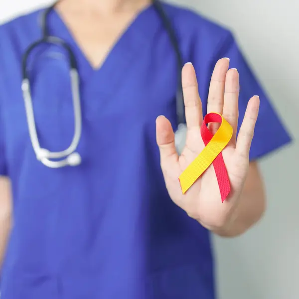 stock image World hepatitis day awareness month, 28 July. Doctor holding Red and Yellow ribbon. Liver cancer, Jaundice, Cirrhosis, Failure, Enlarged, Hepatic Encephalopathy and Health concept