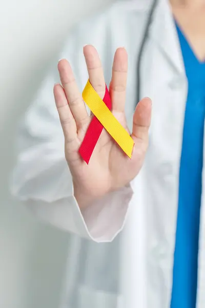 stock image World hepatitis day awareness month, 28 July. Doctor holding Red and Yellow ribbon. Liver cancer, Jaundice, Cirrhosis, Failure, Enlarged, Hepatic Encephalopathy and Health concept