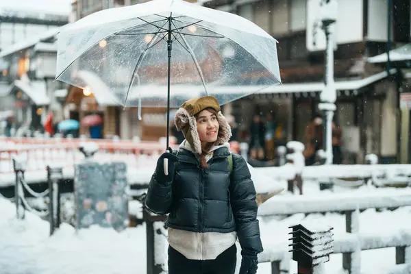 stock image Woman tourist Visiting Ginzan Onsen in Yamagata, happy Traveler sightseeing Japanese Onsen village with Snow in winter season. landmark and popular for attraction in Japan. Travel and Vacation concept