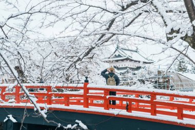 Kışın Hirosaki Kalesi 'ni gezen bir kadın, mutlu bir gezgin Hirosaki şehri, Aomori Bölgesi, Tohoku, Japonya' yı geziyor. Şehir simgesi ve turistik mekanıyla ünlüdür. Japonya seyahat ve tatil