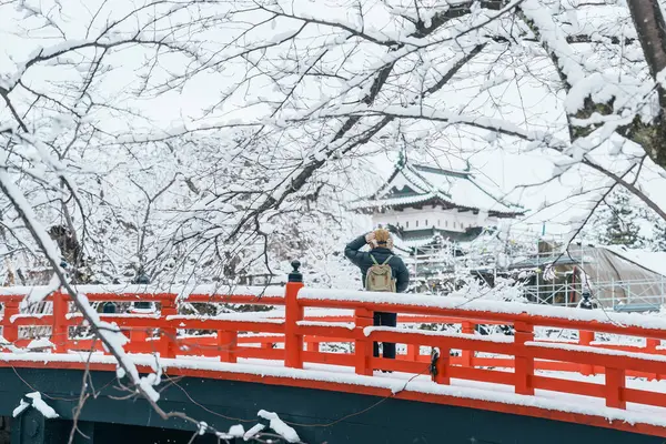 stock image Woman tourist sightseeing Hirosaki Castle in winter, happy traveler travel Hirosaki city, Aomori Prefecture, Tohoku, Japan. Landmark and famous for tourist attraction. Japan travel and vacation