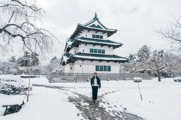 stock image Woman tourist sightseeing Hirosaki Castle in winter, happy traveler travel Hirosaki city, Aomori Prefecture, Tohoku, Japan. Landmark and famous for tourist attraction. Japan travel and vacation