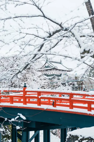 stock image White Hirosaki Castle or Takaoka Castle and red bridge with snow in winter, hirayama style Japanese castle located in Hirosaki city, Aomori Prefecture, Tohoku, Japan. Landmark for tourist attraction