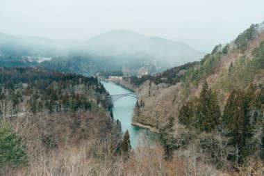 Tadami nehri ve köprüsü olan Japon treninin panoramik görüntüsü. Mishima Machi, Aizu 'daki Tadami Demiryolu Hattı, Fukushima Bölgesi, Japonya. Turistlerin uğrak yeri ve simgesi.