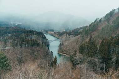 Panoramic View of Japan local train with Tadami river and bridge. Tadami Railway Line in The Valley at Mishima Machi, Aizu, Fukushima Prefecture, Japan. Landmark and iconic spot for tourist attraction clipart