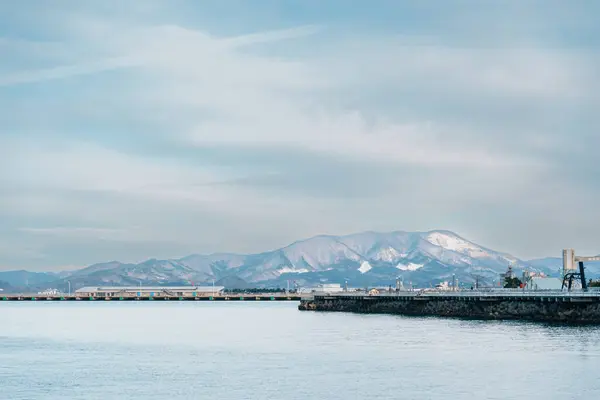 stock image view of ocean and mountains with snow in winter at Aomori Bay Bridge Locate in the city of Aomori in Aomori Prefecture, Japan