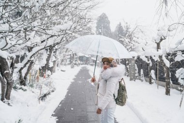 Woman tourist sightseeing Yamadera temple with snow in winter, traveler travel Risshakuji temple in Yamagata City, in Yamagata Prefecture, Tohuku, Japan. Landmark for tourists attraction in Japan clipart