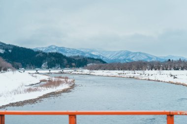 Kış mevsiminde Yokomachi Köprüsü ile Hinokinai Nehri nehir kıyısı. Karlı ve dağlı güzel sakura ağaçları Kakunodate kasabası, Semboku Bölgesi, Akita Bölgesi, Japonya 'da bulunur.