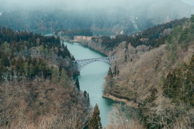 Tadami nehri ve köprüsü olan Japon treninin panoramik görüntüsü. Mishima Machi, Aizu 'daki Tadami Demiryolu Hattı, Fukushima Bölgesi, Japonya. Turistlerin uğrak yeri ve simgesi.